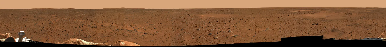 宇宙空間に浮かぶ火星の全球像。赤褐色の地表と白い極冠が見える。
