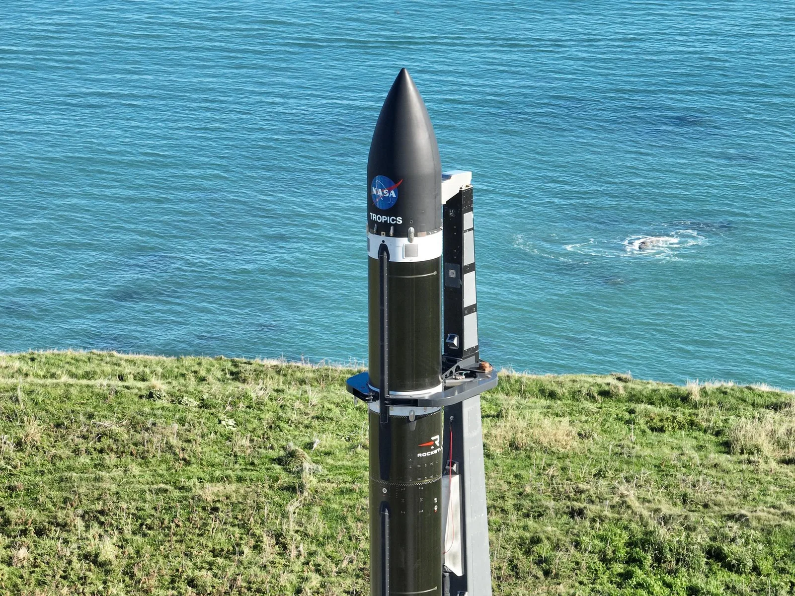射場の発射台に据えられたロケットと支援設備